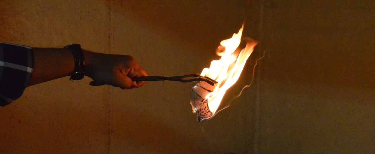 Model huts made of thatched coconut leaves set to fire